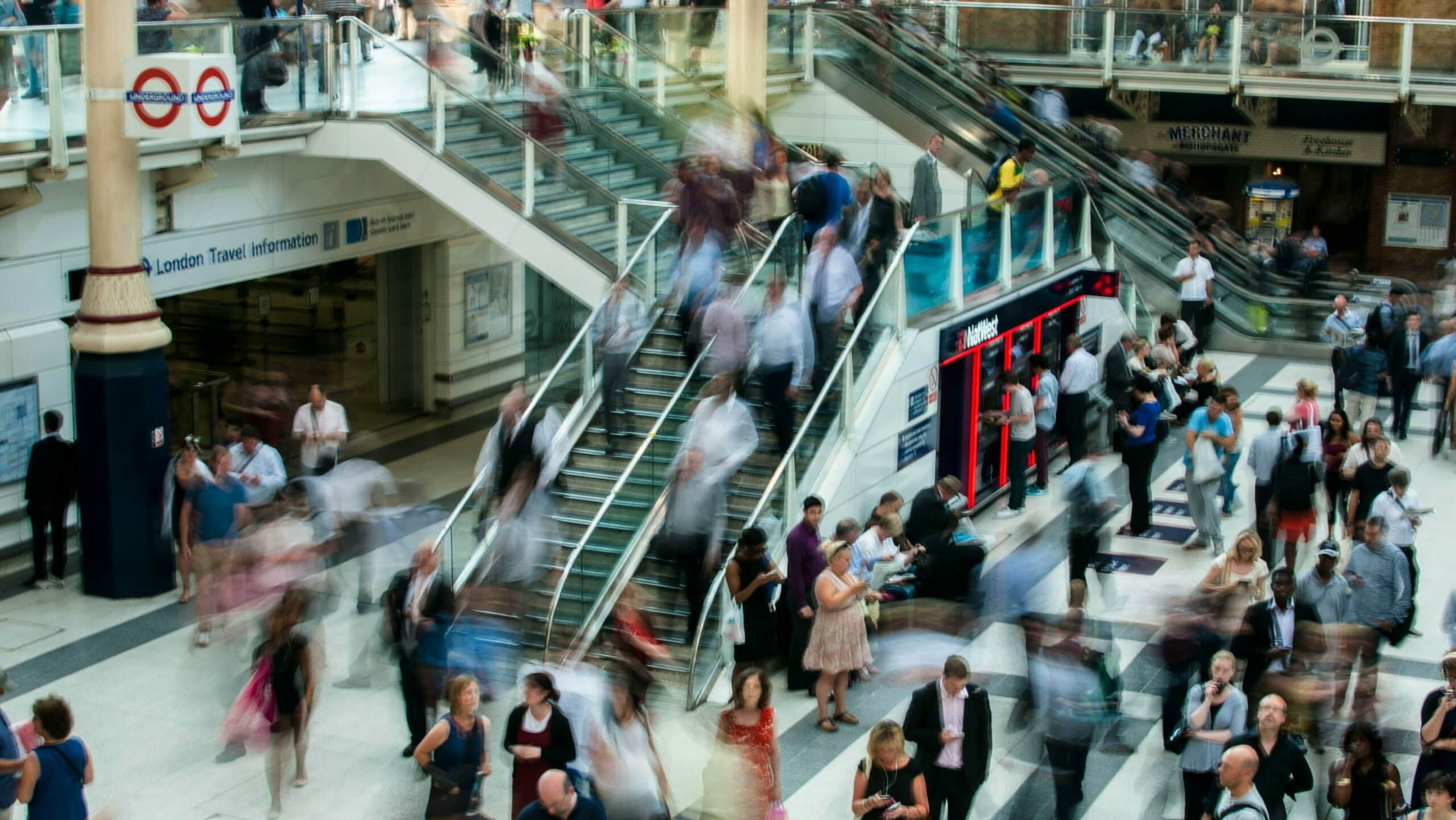 A photograph depicting a throng of people at a London public transport station, illustrating the scale of the world's population in honor of World Population Day.