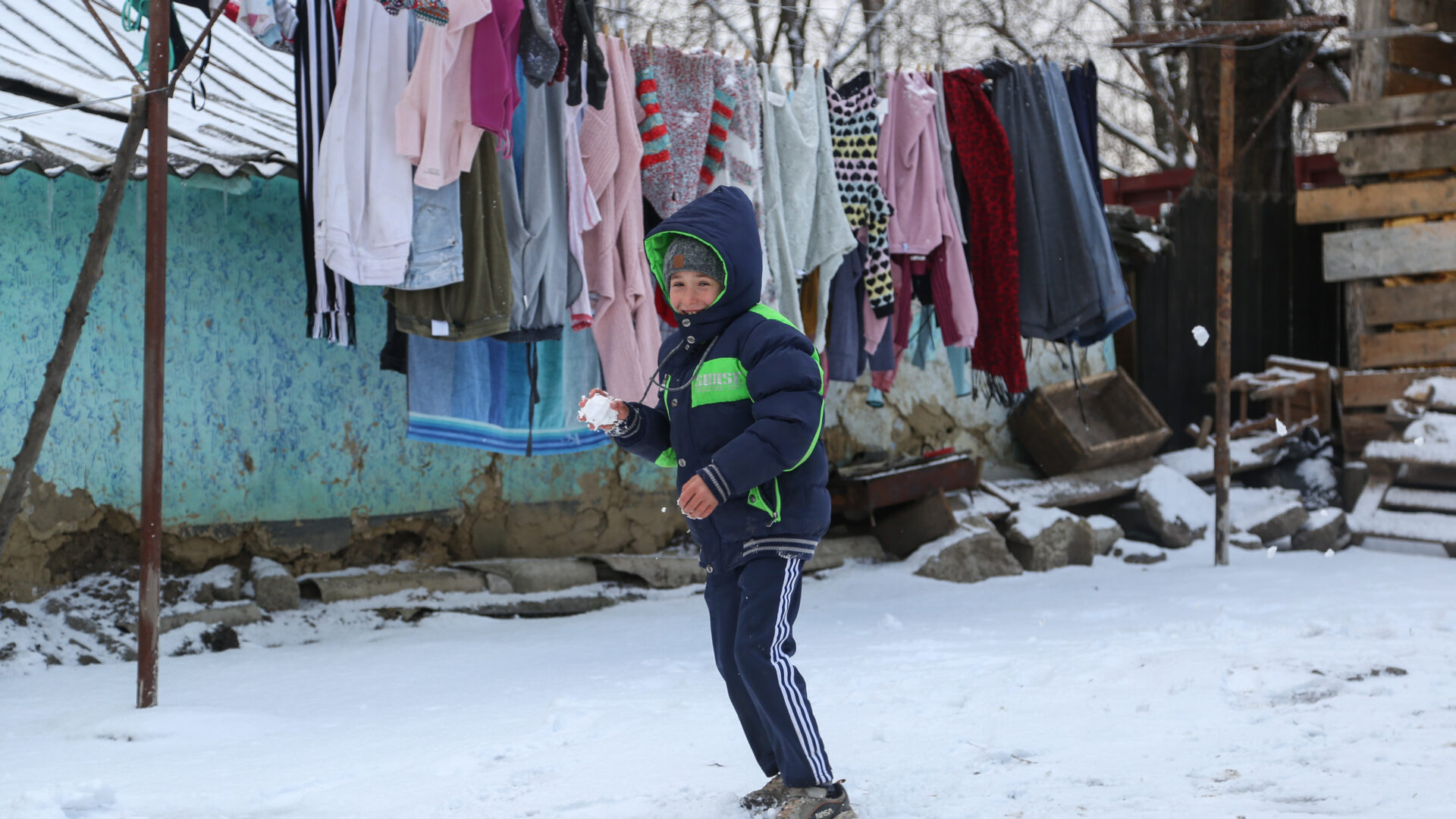 Young boy playing with a snowball