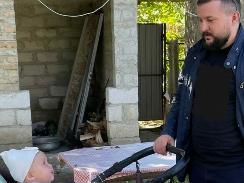 Dragos looking after eight-month-old Nadejda ’Hope’, outside the house where they’re currently staying with relatives. Photo: Hope and Homes for Children