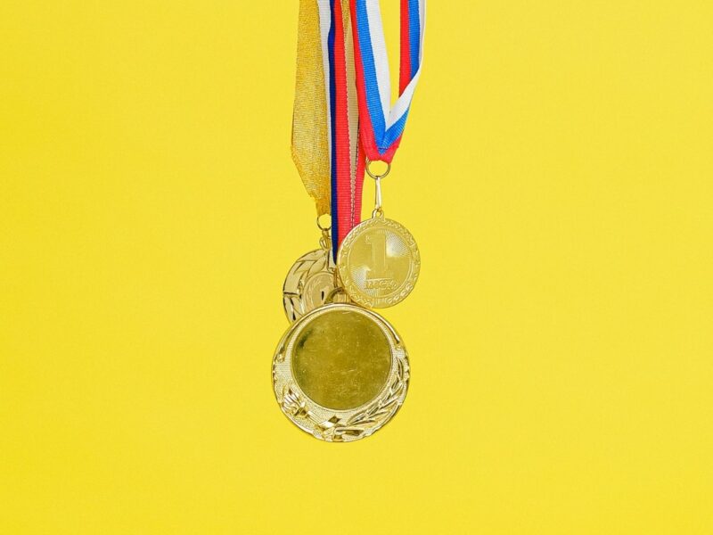 A gold medal on a yellow background