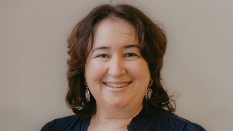 Image is of a woman, Liliana, smiling at camera standing up