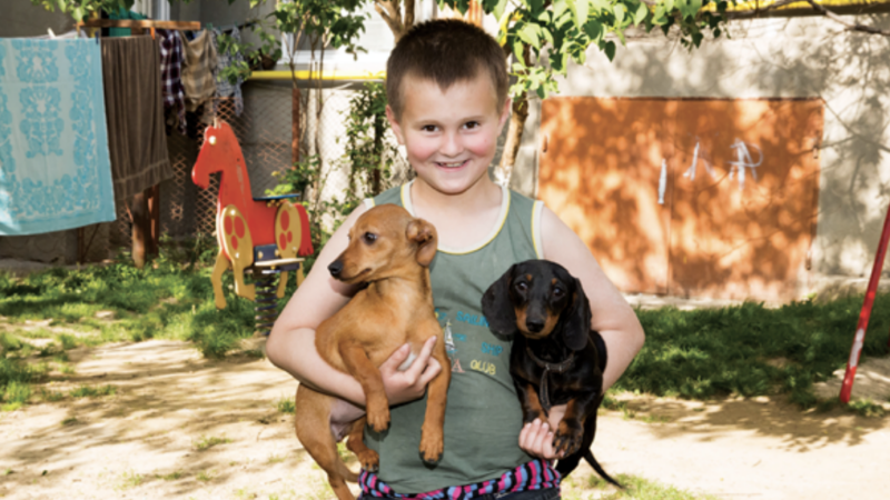 Young boy holding two boys smiling at camera