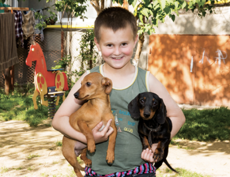 Young boy holding two boys smiling at camera