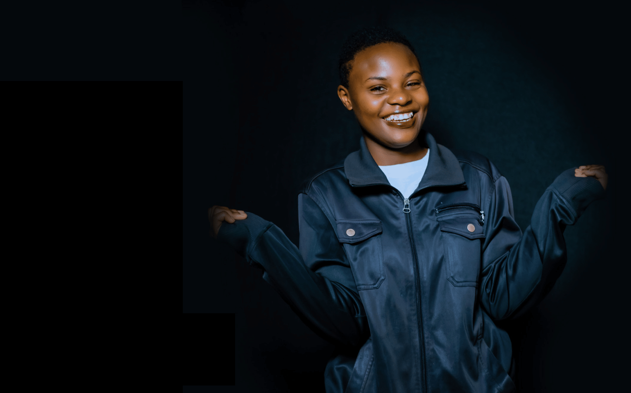 Ombi, a young woman from Rwanda, smiling proudly.